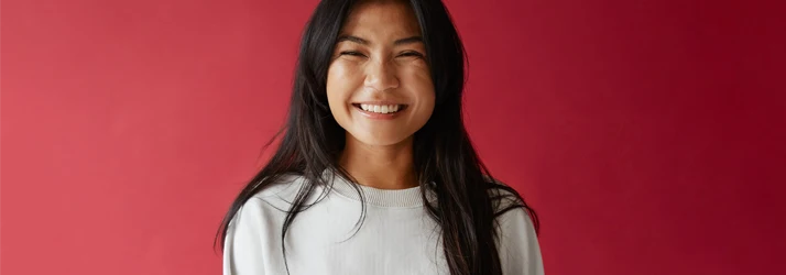 Orthodontist Portland ME Beautiful Woman with Long Brown Hair is Smiling at the Viewer in Front of a Red Backdrop Beautiful Woman with Long Brown Hair is Smiling at the Viewer in Front of a Red Backdrop